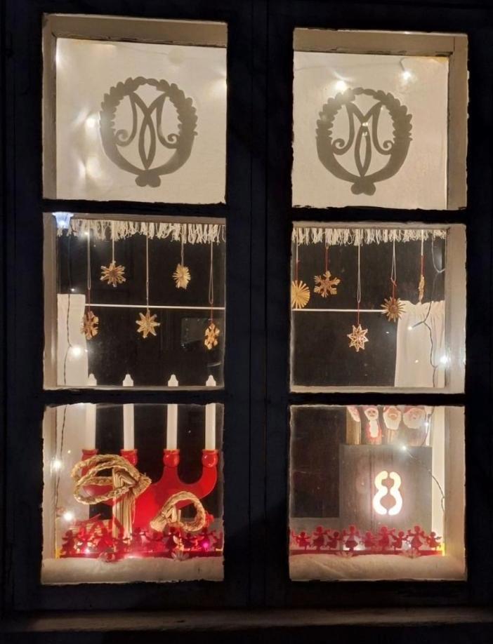 Julkalenderfönstret i Brinkas stugan nr 8. Ljusstake och små tomtar.